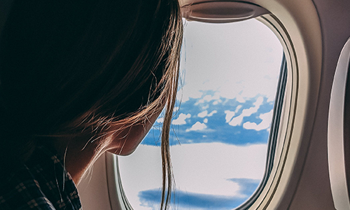Woman looking out window of airplane